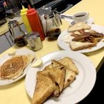 Bigman Breakfast. This picture shows three separate platters that consists of Pancakes, eggs, Bacon, sausage, and home fries on Johnys counter.