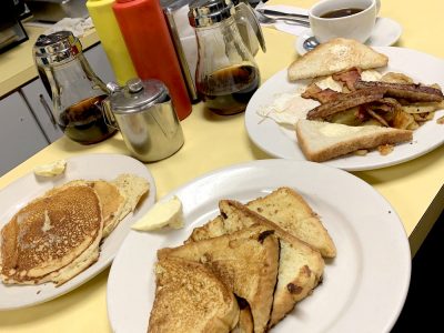Bigman Breakfast. This picture shows three separate platters that consists of Pancakes, eggs, Bacon, sausage, and home fries on Johnys counter.