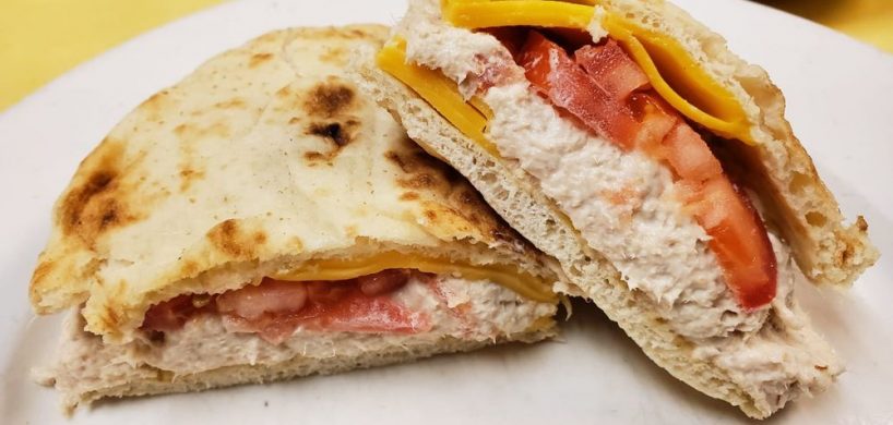 Tuna Melt on Pita. This picture the pics tuna salad with sliced tomatoes melted American cheese on a pita served on a white platter on Johnys Luncheonette